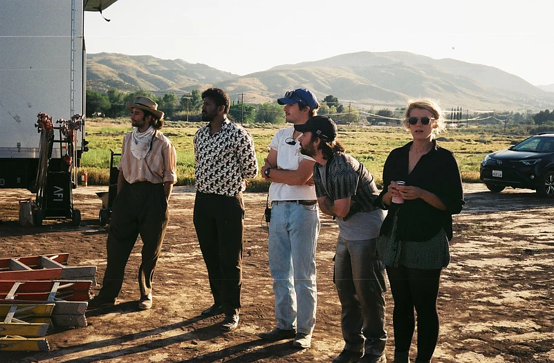 Five people standing outdoors on a film set