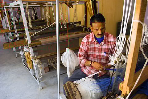 Shawl manufacturing, A local weaver is weaving woolen shawl for tourists with manual hand weaving machines at a Govt. undertaking weaving center near Manali, Himachal Pradesh, India.