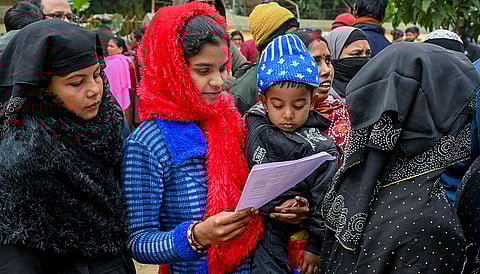 Women wait to enroll for special intensive revision of electoral rolls at Phulia BDO office, in Nadia district, West Bengal.