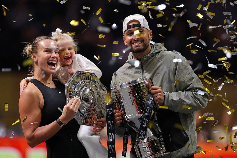Aryna Sabalenka holds her goddaughter next to Nick Kyrgios as they pose with trophies after their Battle of the Sexes tennis match, in Dubai, United Arab Emirates. - | Photo: Amr Alfiky/Pool Photo via AP