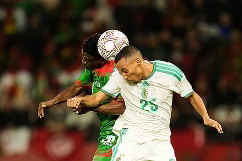 Burkina Faso's Gustavo Sangare, left, competes for the header with Algeria's Rafik Belghali during the Africa Cup of Nations group E soccer match between Algeria and Burkina Faso in Rabat, Morocco.