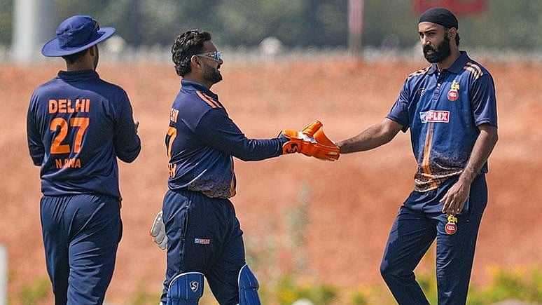 From left, Delhi's Nitish Rana with captain Rishabh Pant and teammates Simarjeet Singh celebrates a dismissal during the Vijay Hazare Trophy 2025-26 cricket match between Andhra and Delhi, at BCCI Centre of Excellence Ground, in Bengaluru. - | Photo: PTI/Shailendra Bhojak