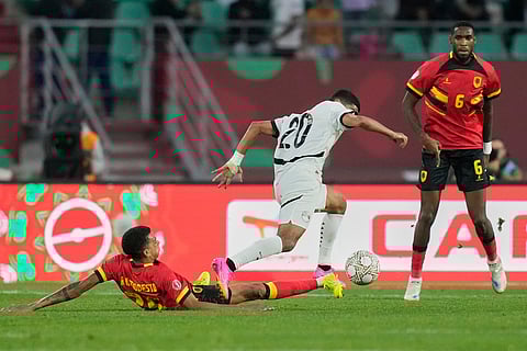 Angola's Rui Modesto, left, tackles Egypt's Ibrahim Adel compete for the ball during the Africa Cup of Nations group B soccer match between Angola and Egypt in Agadir, Morocco.