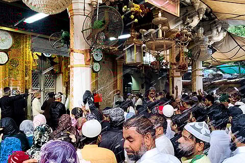 Devotees gather as perfumed water is being showered as part of rituals during the closing ceremony of the annual Urs festival, at Ajmer Sharif Dargah.