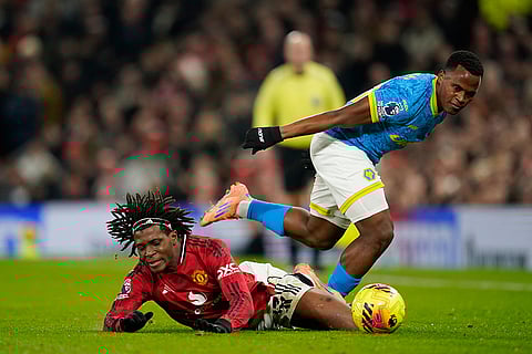 Manchester United's Patrick Dorgu and Wolverhampton Wanderers' Jhon Arias challenge for the ball during the English Premier League soccer match between Manchester United and Wolverhampton Wanderers in Manchester, England.