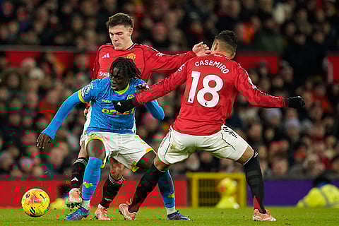 Wolverhampton Wanderers' Mateus Mane, Manchester United's Manuel Ugarte and Manchester United's Casemiro challenge for the ball during the English Premier League soccer match between Manchester United and Wolverhampton Wanderers in Manchester, England.