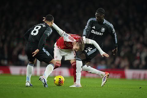 Arsenal's Martin Odegaard, centre, challenges for the ball with Aston Villa's Amadou Onana, right, and Aston Villa's Youri Tielemans during the English Premier League soccer match between Arsenal and Aston Villa in London.