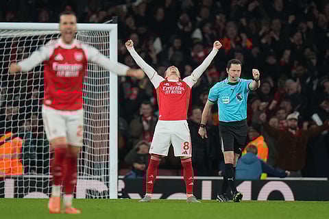Arsenal's Martin Odegaard celebrates after his teammate Arsenal's Leandro Trossard scored his side's third goal during the English Premier League soccer match between Arsenal and Aston Villa in London.