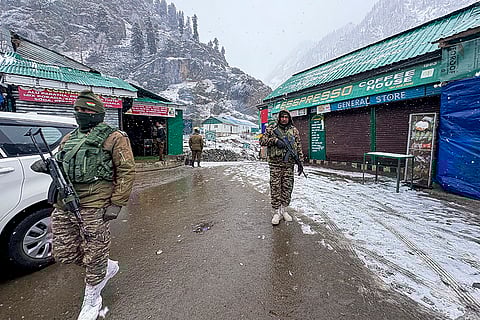 Security personnel keep vigil after the area received fresh snowfall, in Chandanwari, Anantnag district.