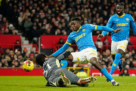 Wolverhampton Wanderers' Yerson Mosquera and Manchester United's goalkeeper Senne Lammens challenge for the ball during the English Premier League soccer match between Manchester United and Wolverhampton Wanderers in Manchester, England.