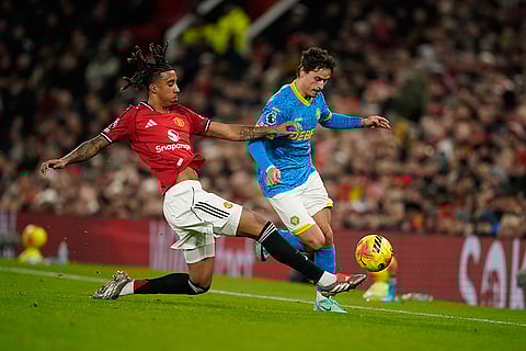 Manchester United's Leny Yoro and Wolverhampton Wanderers' Hugo Bueno challenge for the ball during the English Premier League soccer match between Manchester United and Wolverhampton Wanderers in Manchester, England.