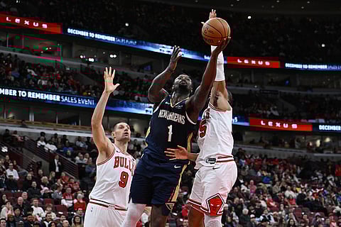 New Orleans Pelicans' Zion Williamson (1) goes up for a shot against Chicago Bulls' Isaac Okoro, right, and Nikola Vucevic (9) during the first half of an NBA basketball game in Chicago.