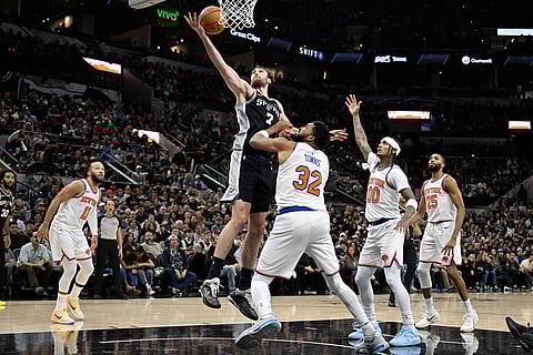 San Antonio Spurs center Luke Kornet (7) grabs the rebound against New York Knicks center Karl-Anthony Towns (32) during the second half of an NBA basketball game in San Antonio.