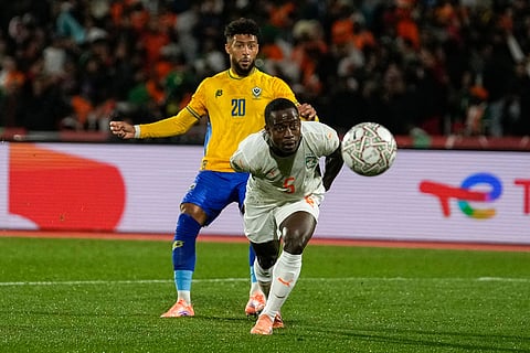 Gabon's Denis Bouanga is challenged by Ivory Coast's Armel Zohouri as he scores a goal during the Africa Cup of Nations group F soccer match between Gabon and Ivory Coast, in Marrakech, Morocco.