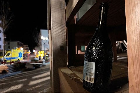 A bottle of sparkling wine lies where a fire broke out leaving people dead and injured, during New Year’s celebration, in Crans-Montana, Swiss Alps, Switzerland.