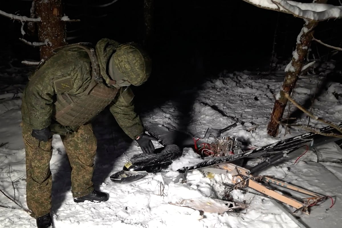 This image made from undated video provided by the Russian Defense Ministry Press Service on Wednesday, Dec. 31, 2025, shows a man in camouflage standing by a downed drone at an undisclosed location that it said was one of the Ukrainian drones involved in an alleged attack on a residence. - AP