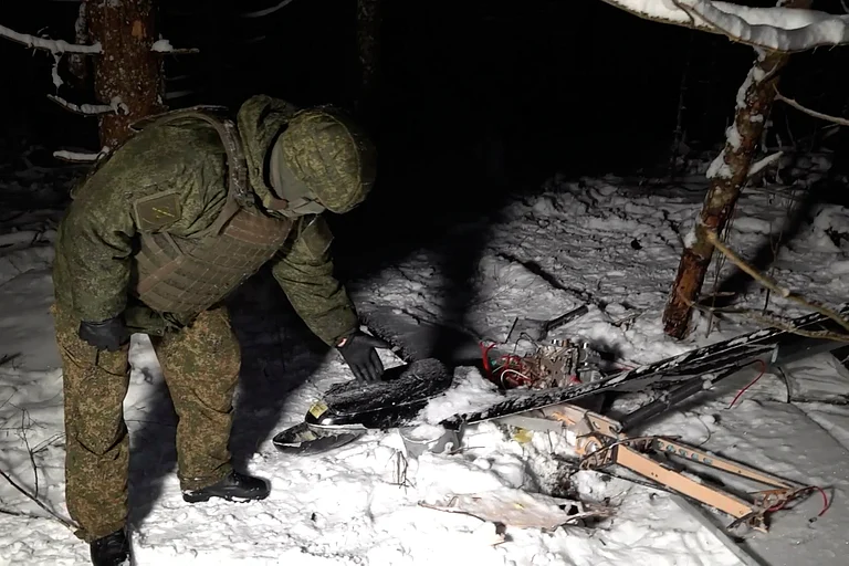 This image made from undated video provided by the Russian Defense Ministry Press Service on Wednesday, Dec. 31, 2025, shows a man in camouflage standing by a downed drone at an undisclosed location that it said was one of the Ukrainian drones involved in an alleged attack on a residence. - AP