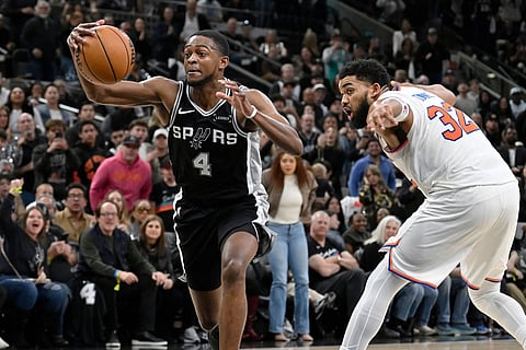 San Antonio Spurs guard De'Aaron Fox (4) tangles with New York Knicks center Karl-Anthony Towns during the second half of an NBA basketball game in San Antonio.