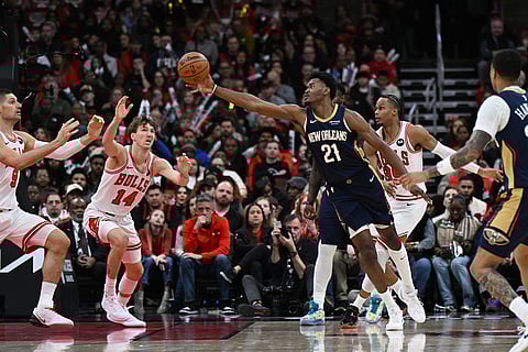 New Orleans Pelicans' Yves Missi (21) battles Chicago Bulls' Matas Buzelis (14), Isaac Okoro (35) and Nikola Vucevic (9) for a loose ball during the second half of an NBA basketball game in Chicago.