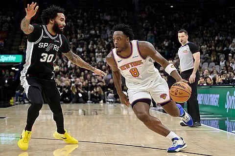 New York Knicks guard OG Anunoby (8) drives against San Antonio Spurs forward Julian Champagnie during the first half of an NBA basketball game in San Antonio.