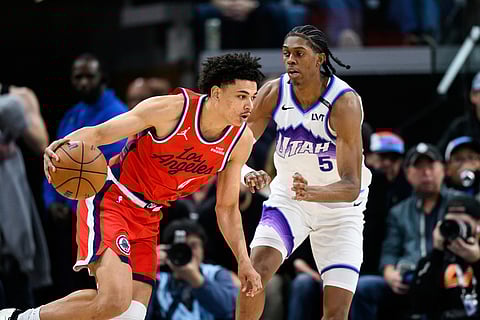 Los Angeles Clippers guard Kobe Sanders, left, drives the ball against Utah Jazz forward Cody Williams (5) during the second half of an NBA basketball game in Inglewood, California.