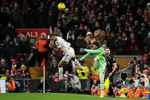Liverpool's goalkeeper Alisson, right, and Leeds' Dominic Calvert-Lewin challenge for the ball during the English Premier League soccer match between Liverpool and Leeds United in Liverpool, England.