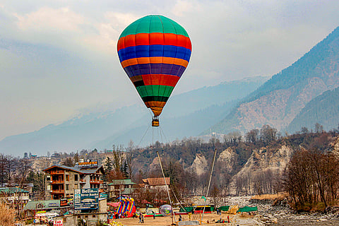 A hot air balloon floats over Mall Road amid winter chill as tourists visit the hill destination, in Manali.