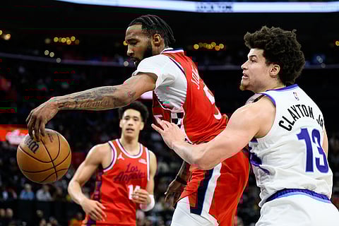 Los Angeles Clippers forward Derrick Jones Jr., center, goes for a rebound while under pressure from Utah Jazz guard Walter Clayton Jr. (13) during the second half of an NBA basketball game in Inglewood, California. 