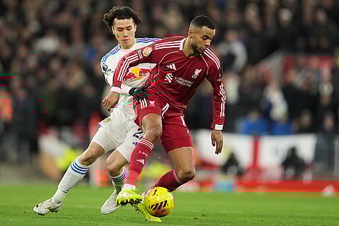 Liverpool's Cody Gakpo, front, and Leeds' Ao Tanaka challenge for the ball during the English Premier League soccer match between Liverpool and Leeds United in Liverpool, England.