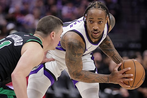 Sacramento Kings guard Demar Derozan, right, looks on while being guarded by Boston Celtics guard Payton Pritchard, left, during the second half of an NBA basketball game in Sacramento, California. 