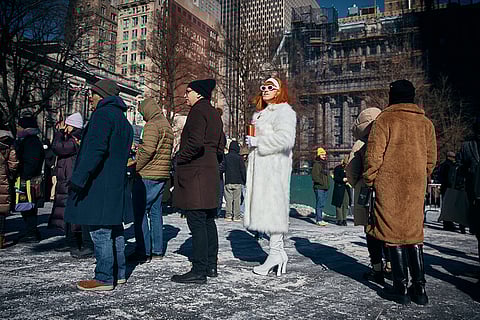 Kiki Ball-Change of Harlem, in white, waits with others in the cold outside the City Hall before Zohran Mamdani's inauguration in New York. 