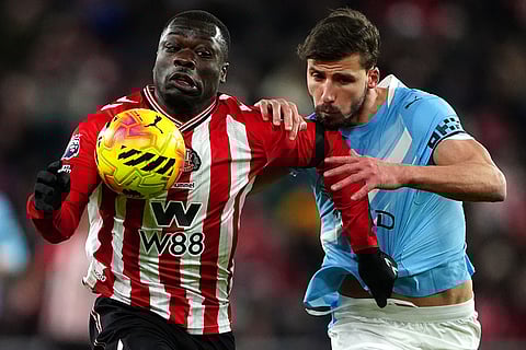Sunderland's Brian Brobbey, left, and Manchester City's Ruben Dias in action during the English Premier League soccer match between Sunderland and Manchester City in Sunderland, England.