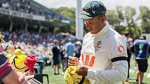 | Photo: AP/James Elsby : Australia's Usman Khawaja sign autograph to fans after they won the third Ashes cricket test match against England in Adelaide, Australia.