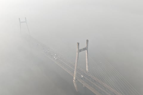 An aerial view of Naini Bridge over the Yamuna river as dense fog occurs during a cold winter morning, in Prayagraj.