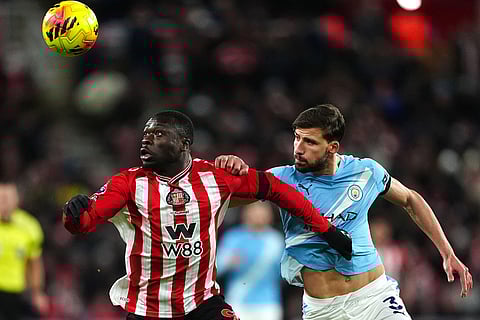 Sunderland's Brian Brobbey, left, and Manchester City's Ruben Dias in action during the English Premier League soccer match between Sunderland and Manchester City in Sunderland, England.