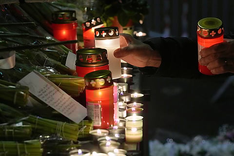 People lay candles and flowers near the Le Constellation bar, where a devastating fire left dead and injured during the New Year's celebrations in Crans-Montana, Swiss Alps, Switzerland.