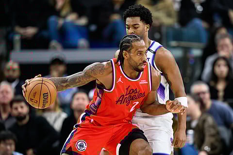 Los Angeles Clippers forward Kawhi Leonard, left, drives the ball while under pressure from Utah Jazz forward Brice Sensabaugh during the second half of an NBA basketball game in Inglewood, California.