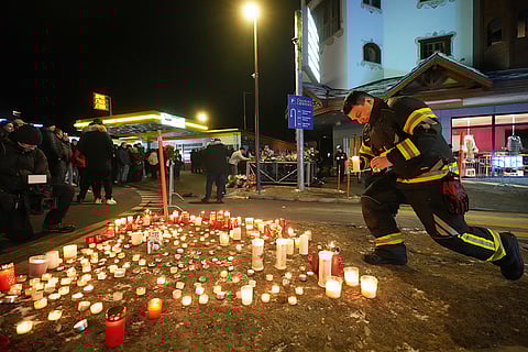 People lay candles and flowers near the Le Constellation bar, where a devastating fire left dead and injured during the New Year's celebrations in Crans-Montana, Swiss Alps, Switzerland.