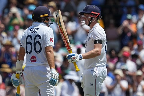 England's Harry Brook is congratulated by teammate Joe Root, left, after scoring 50 runs during play on day one of the fifth and final Ashes cricket test between England and Australia in Sydney.