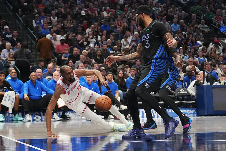 Houston Rockets forward Kevin Durant, left, falls to the floor while attacking against Dallas Mavericks forward Anthony Davis (3) and a teammate during the first half of an NBA basketball game in Dallas. - | Photo: AP/Julio Cortez