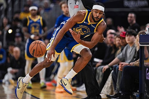 Golden State Warriors guard Moses Moody (4) tosses the ball back inbounds during the first half of an NBA basketball game against the Utah Jazz in San Francisco.