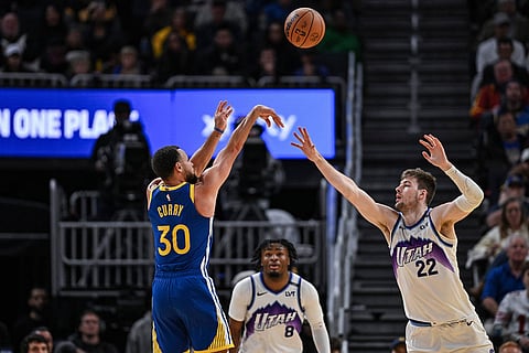 Golden State Warriors guard Stephen Curry (30) shoots a 3-point basket over Utah Jazz forward Kyle Filipowski (22) during the second half of an NBA basketball game in San Francisco.