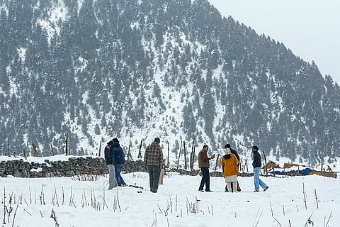 Tourists witness light snowfall amid snow-covered mountains and meadows, in Sonamarg, Jammu and Kashmir.