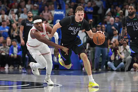 Dallas Mavericks forward Cooper Flagg, right, drives against Houston Rockets guard Aaron Holiday during the second half of an NBA basketball game in Dallas.