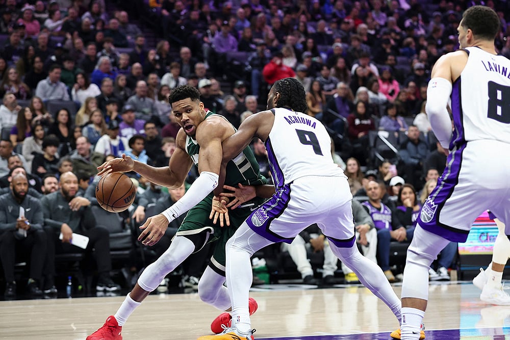Milwaukee Bucks forward Giannis Antetokounmpo, left, drives to the basket with Sacramento Kings forward Precious Achiuwa (9) defending during the first half of an NBA basketball game in Sacramento, California.  - | Photo: AP/Sara Nevis