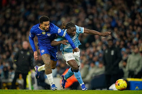 Chelsea's Tosin Adarabioyo, left, and Manchester City's Jeremy Doku fight for the ball during the English Premier League soccer match between Manchester City and Chelsea in Manchester, England.