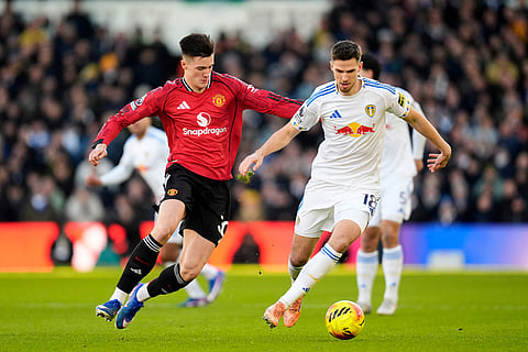 Manchester United's Benjamin Sesko, left, and Leeds United's Anton Stach battle for the ball during the English Premier League soccer match between Leeds United and Manchester United in Leeds, England.