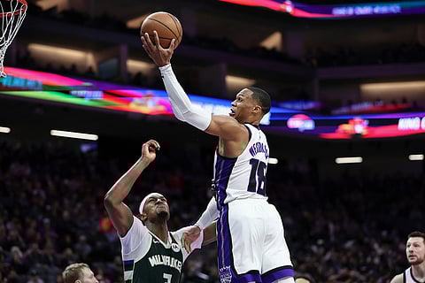 Sacramento Kings guard Russell Westbrook, right, attempts a layup over Milwaukee Bucks center Myles Turner, left, during the second half of an NBA basketball game in Sacramento, California.