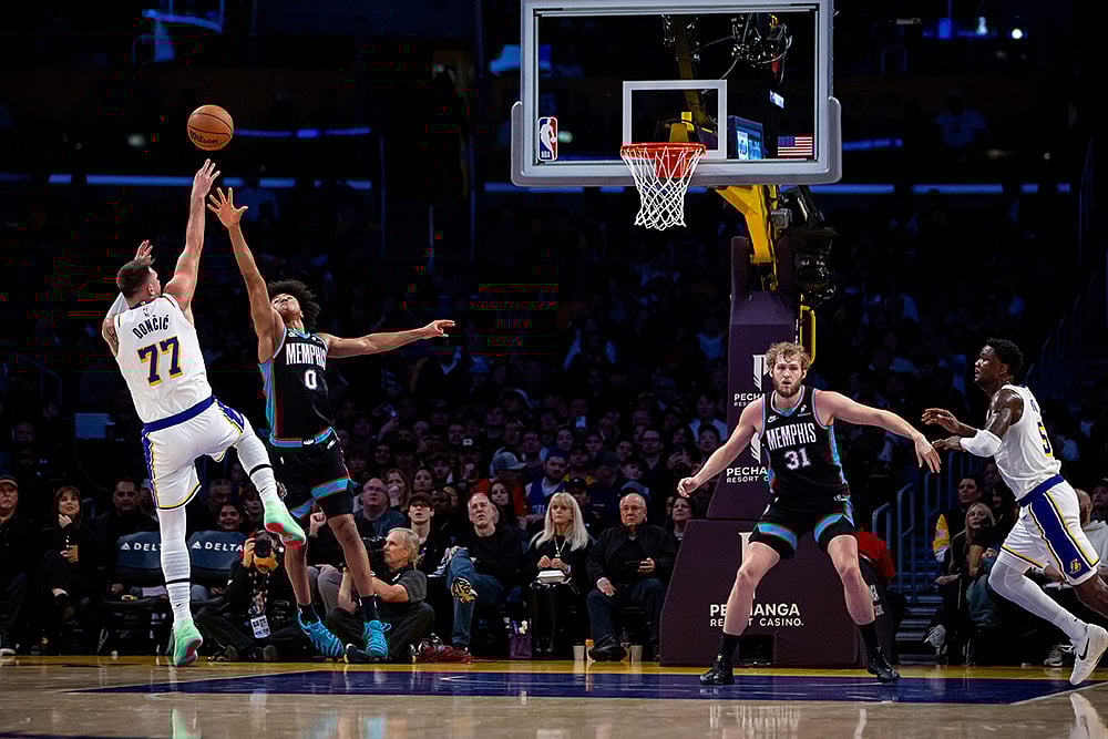 Los Angeles Lakers guard Luka Doncic (77) shoots against Memphis Grizzlies forward Jaylen Wells (0) during the first half of an NBA basketball game in Los Angeles.  - | Photo: AP/Ethan Swope