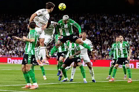 Betis' Cucho Hernandez, center, jumos for the ball during the Spanish La Liga soccer match between Real Madrid and Real Betis Sevilla in Madrid, Spain.
